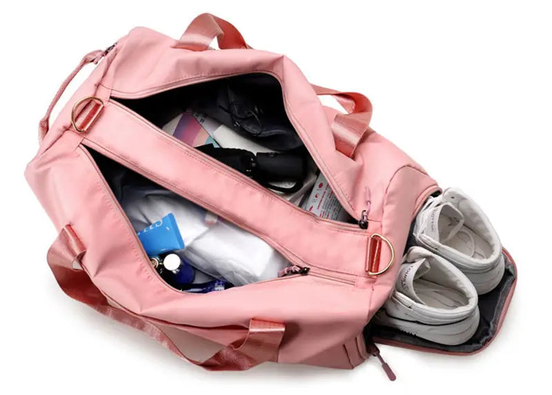 Pink nylon waterproof Oxford travel duffel bag with matching handles and gold-tone metal hardware designed for gym and sports use.