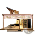 A shimmering rose gold and glittery pink polyester 16th birthday happy and sweet party banner with cascading confetti hanging on wooden beams