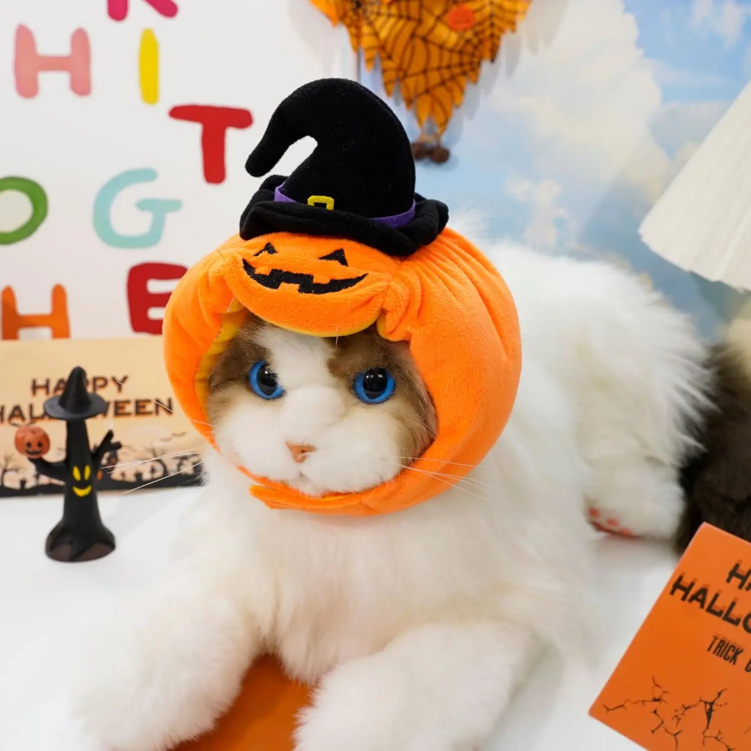 Costume orange en peluche pour chien en forme de citrouille avec un chapeau de sorcière noir sur le dessus, conçu pour un costume pour animal de compagnie destiné à Halloween.