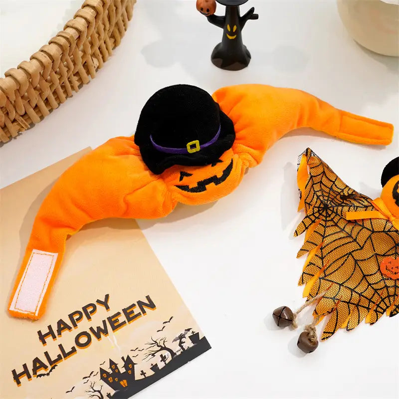 Bandeau de tête orange en peluche pour animal de compagnie en forme de citrouille avec un chapeau de sorcière noir, comportant une bande violette et une boucle jaune pour un accessoire de costume pour chien destiné à Halloween.