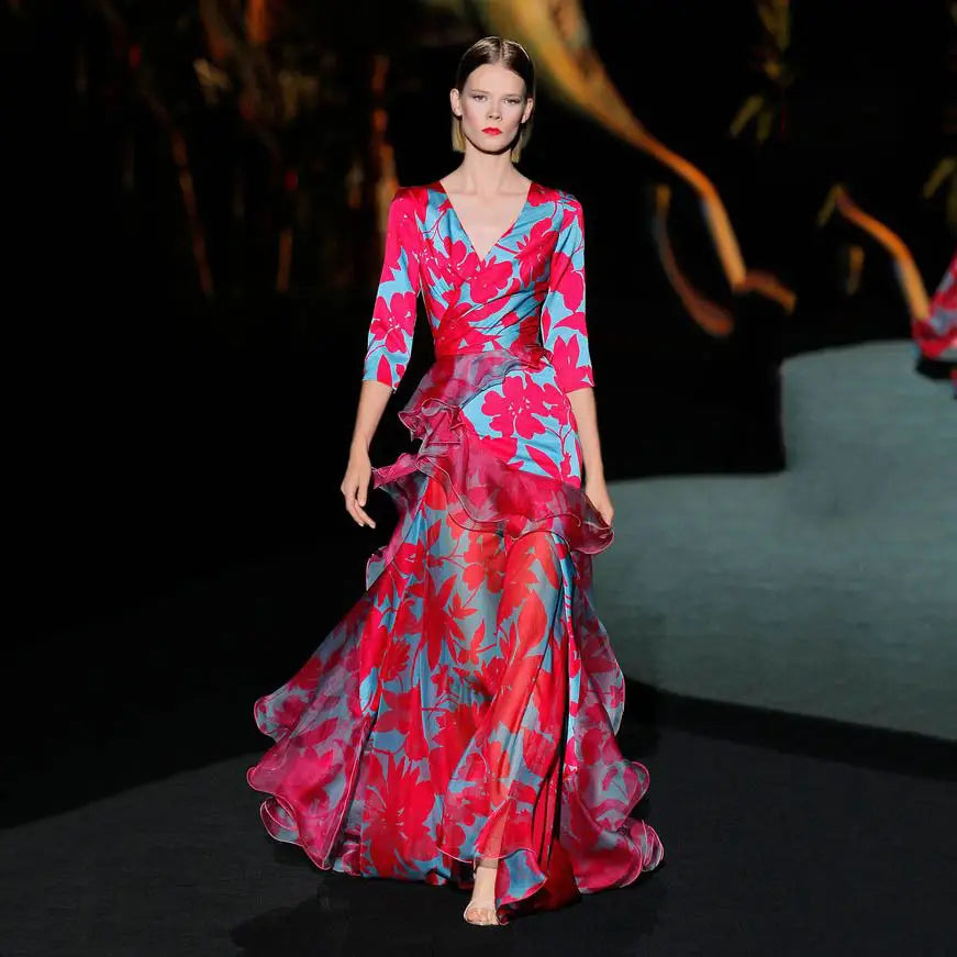 A floral tiered maxi dress with ruffled layers featuring a flowing floor-length gown in vibrant pink and blue floral print.