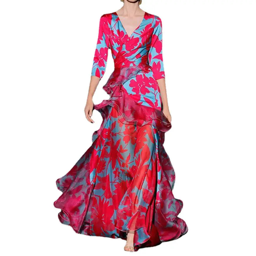 A flowing floor-length floral tiered maxi dress with ruffled layers in vibrant pink and teal floral print.