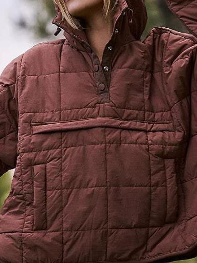 A quilted maroon women cotton hooded puffer jacket with a half-zip front and button closure.