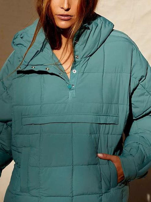 Women cotton quilted puffer jacket in teal with a hood and front button closure.