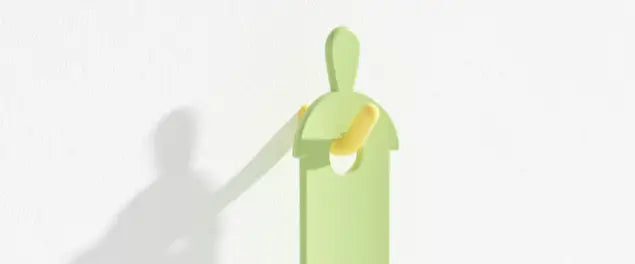 Extrudeuse de friandises pour chat en silicone minimaliste de couleur vert clair, à forme humaine, avec un détail cylindrique jaune sur son bras pour distribuer la nourriture pour animaux.