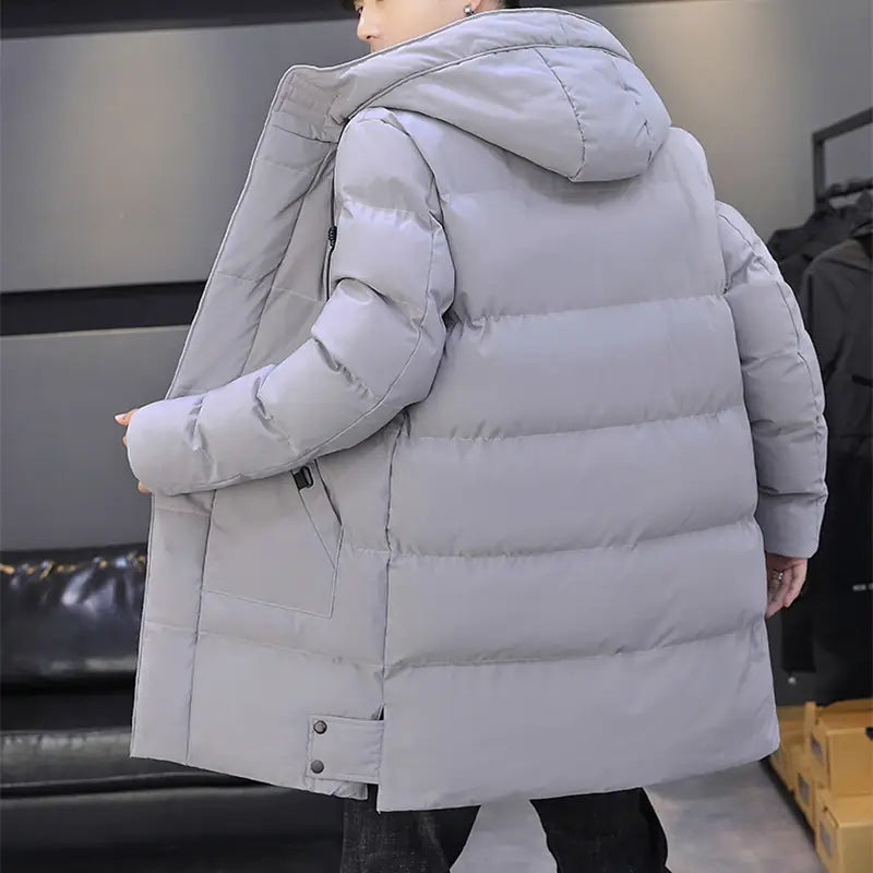 Veste matelassée pour homme gris clair coupe-vent à capuche, avec fermeture à glissière à l’avant, conçue pour les temps froids.