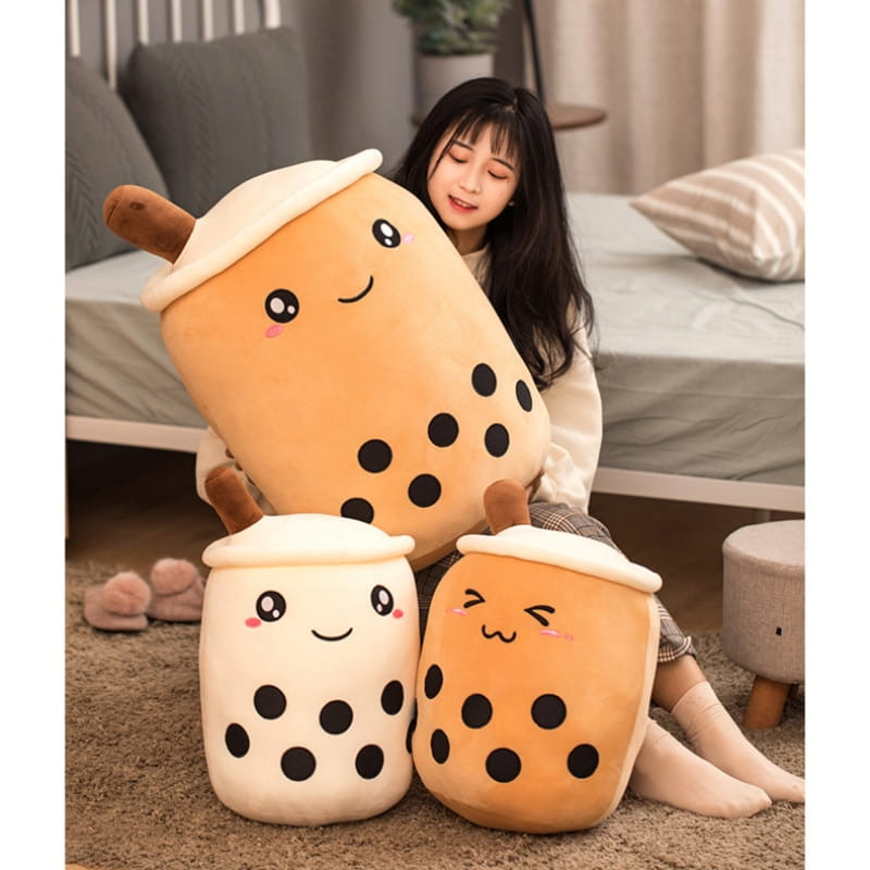 Cute orange and white boba tea plush soft bubble tea pillow toys with black tapioca pearls smiling faces and brown wooden spoons.
