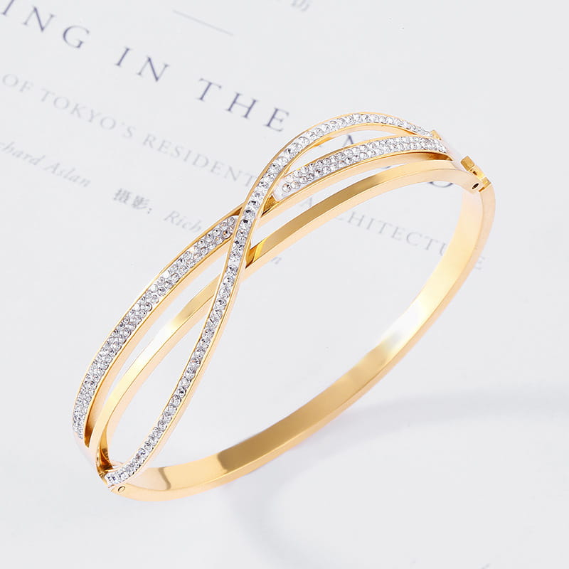 Gold-toned geometric crystal inlaid titanium steel rose gold bangle featuring a sleek intertwined design adorned with sparkling clear crystals.