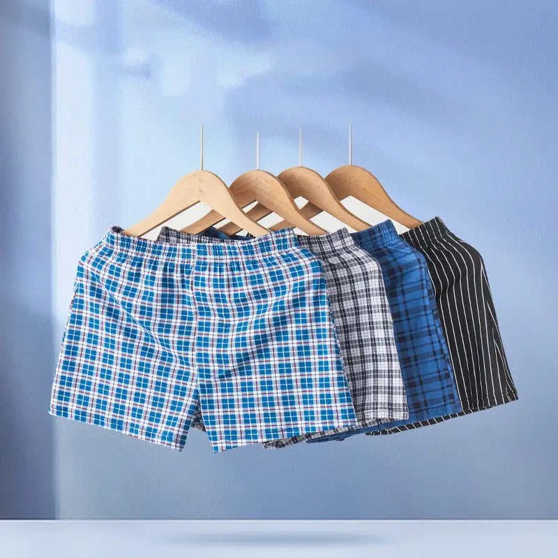 Men’s plus size cotton striped and plaid boxer shorts in blue and white plaid hanging on wooden hangers.