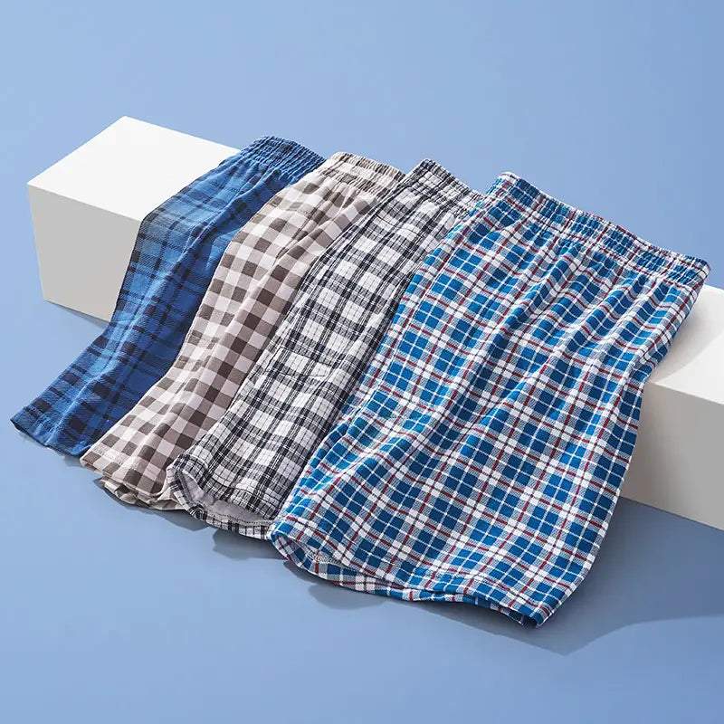 Four pairs of men’s plus size cotton striped and plaid boxer shorts in various blue beige and black patterns.