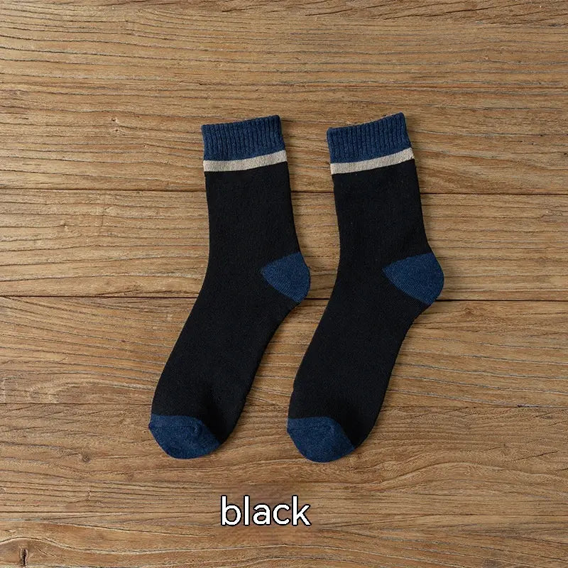 Thermal terry tube socks for men in black with navy blue toe and heel accents and a ribbed cuff featuring a thin white stripe.