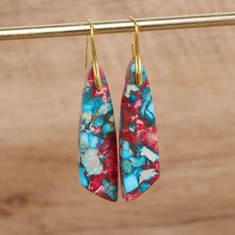 Mosaik-geometrische Steinblumen-Tropfen-Ohrringe mit leuchtenden rot- und blau marmorierten Steinen sowie goldfarbenen Haken.