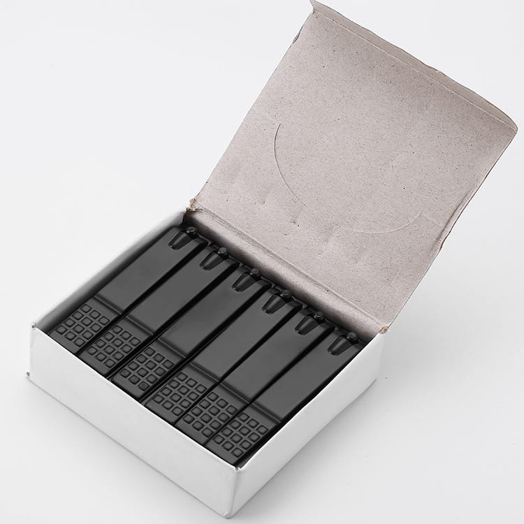 Black plastic matchsticks with textured grid patterned heads arranged in a white cardboard box alongside stainless steel nail clippers with textured grip.