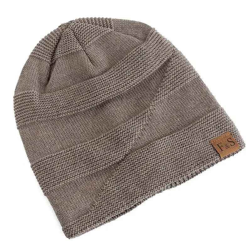 a taupe fleece lined knitted beanie cap with ribbed texture and horizontal stripes featuring a small brown leather patch on the side