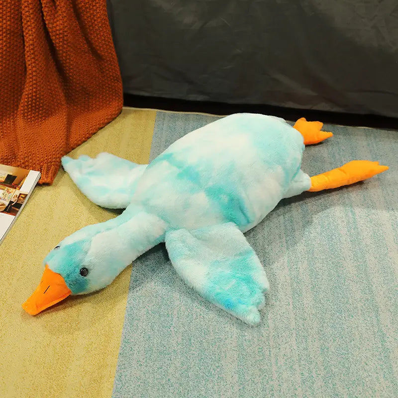 Giant white goose plush sleeping pillow toy in plush teal and white tie-dye with orange beak and feet.