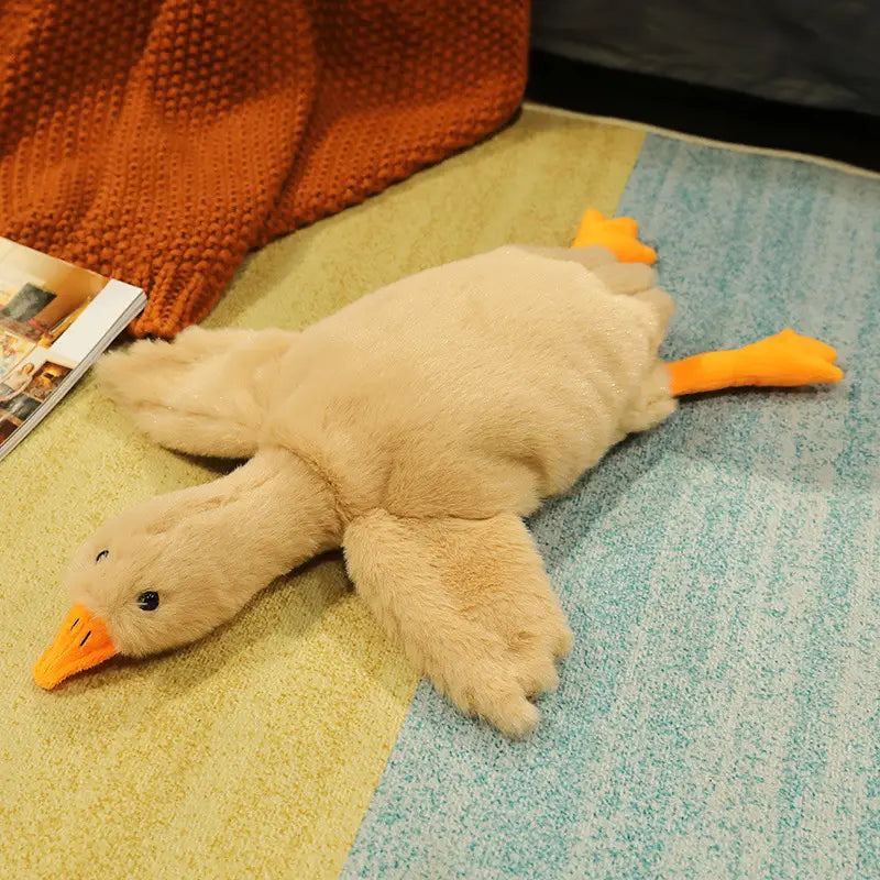 A giant white goose plush sleeping pillow toy with plush beige soft fur material and orange beak and feet.