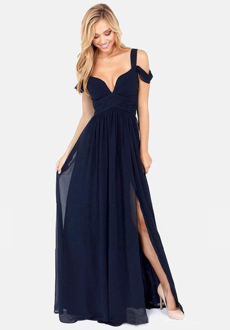 Un vestido maxi plisado floral de gasa azul marino con escote pronunciado en V, correas descubiertas en los hombros y una abertura alta en el lateral.