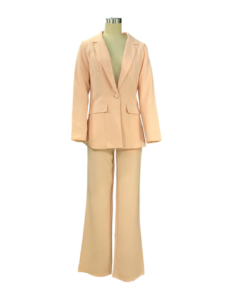 A soft peach-colored women’s tailored blazer and wide leg trouser suit set made from smooth fabric featuring a fitted blazer and flared trousers.