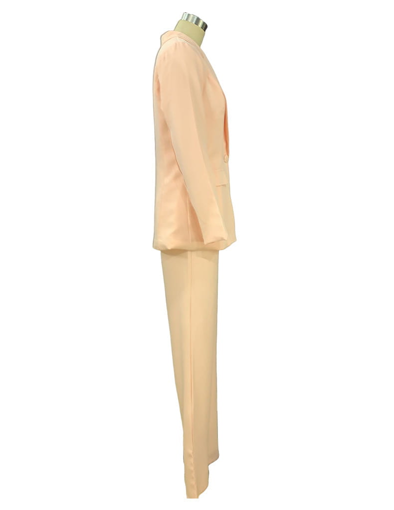 A peach-colored tailored blazer and wide leg trouser suit set displayed on a mannequin showcasing the front view.