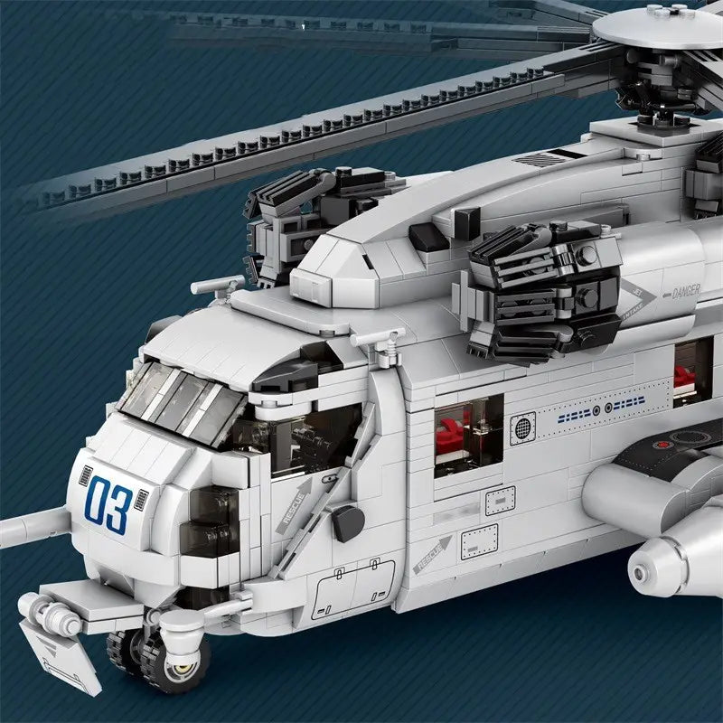 Modèle-jouet en blocs de construction de type Lego représentant un hélicoptère de transport Ch-53 en blanc et gris, avec une cabine détaillée, des pales de rotor et des armes montées.