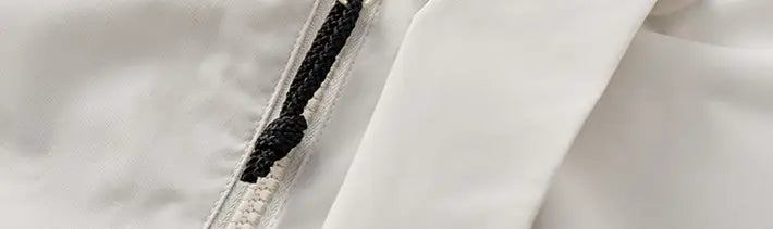 Cierre de nailon blanco con tirador trenzado negro en una chaqueta de caparazón impermeable 3 en 1 para parejas
