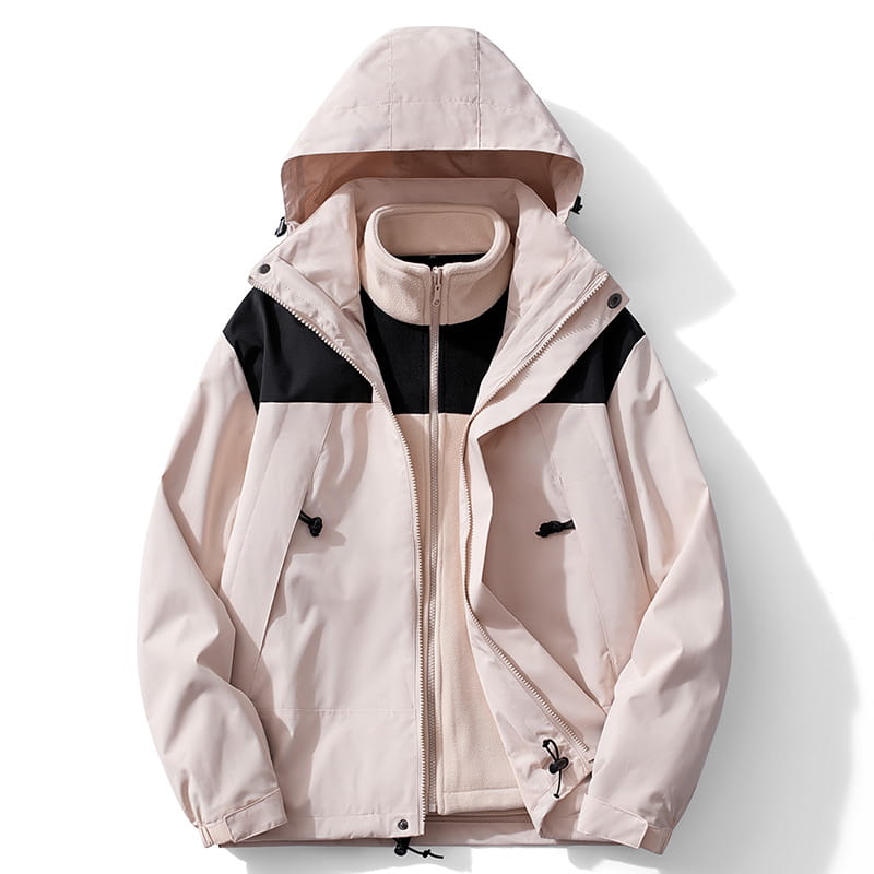 Chaqueta de caparazón impermeable 3 en 1 para parejas color beige y negro con capucha desmontable confeccionada con tejido repelente al agua, con bolsillos con cremallera diseñados para uso en exteriores.