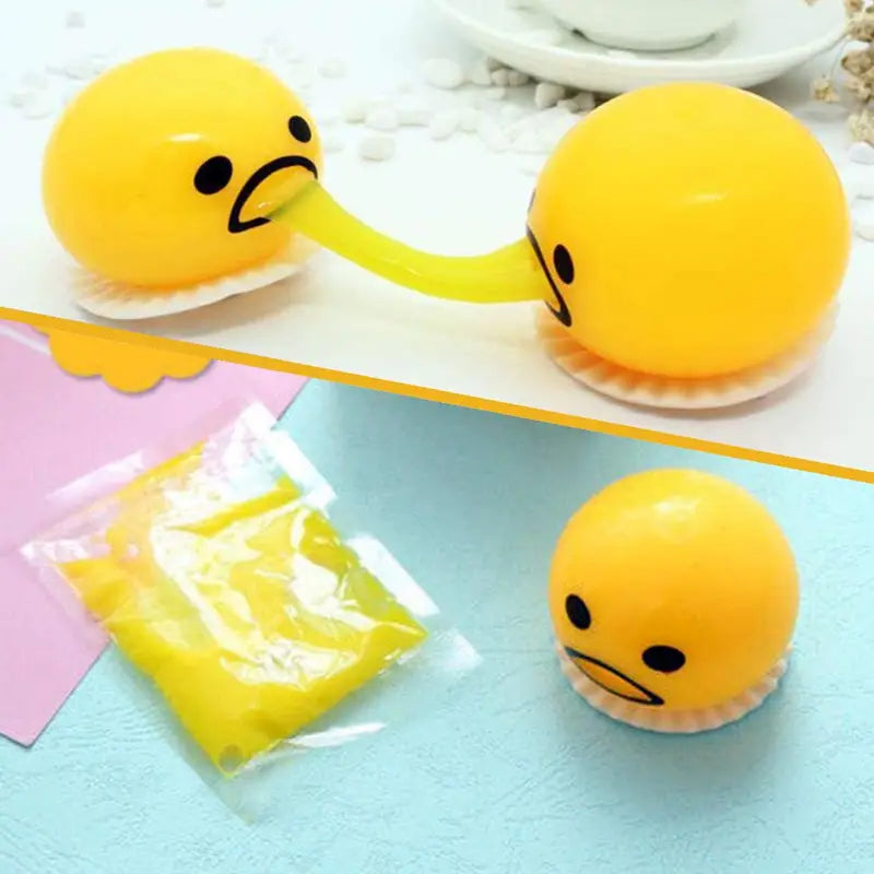 Yellow gudetama vomiting egg yolk stress relief toy featuring a stretchy yellow noodle-like appendage connecting two round heads made of soft stress ball material.