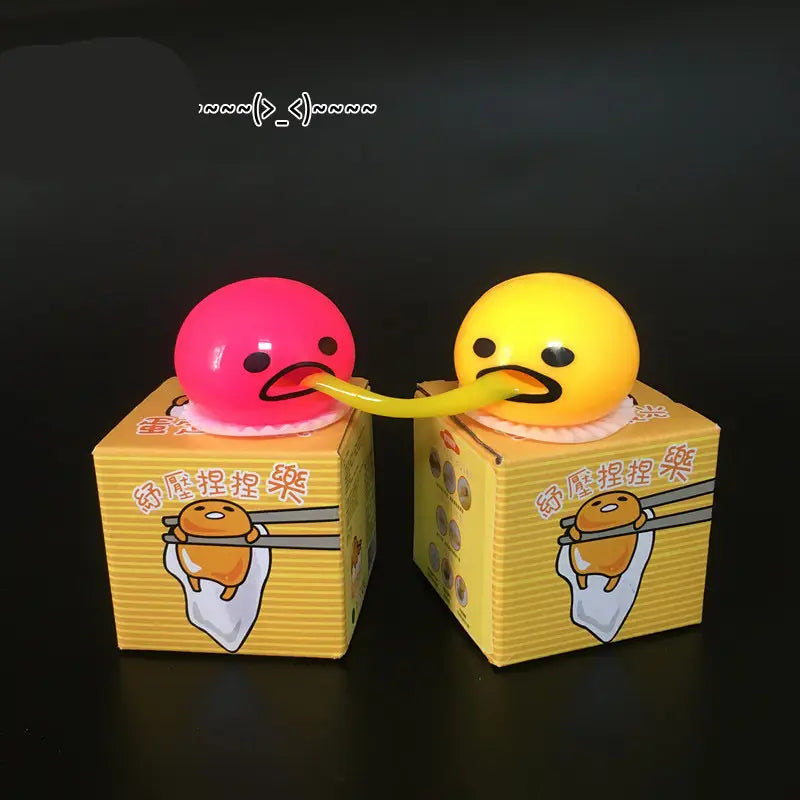 pink and yellow gudetama vomiting egg yolk stress relief toys with long flexible tongues extending from their boxes for stress relief