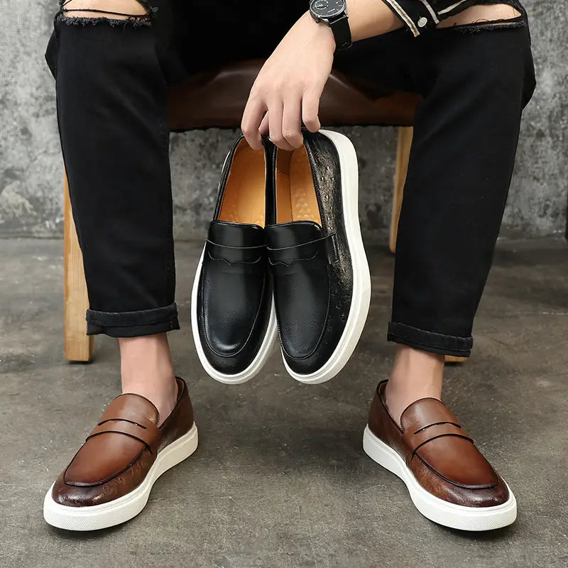 mocasines de cuero con relieve estilo británico para hombres en negro y marrón con suelas de goma blancas, mostrados desde el lado posterior