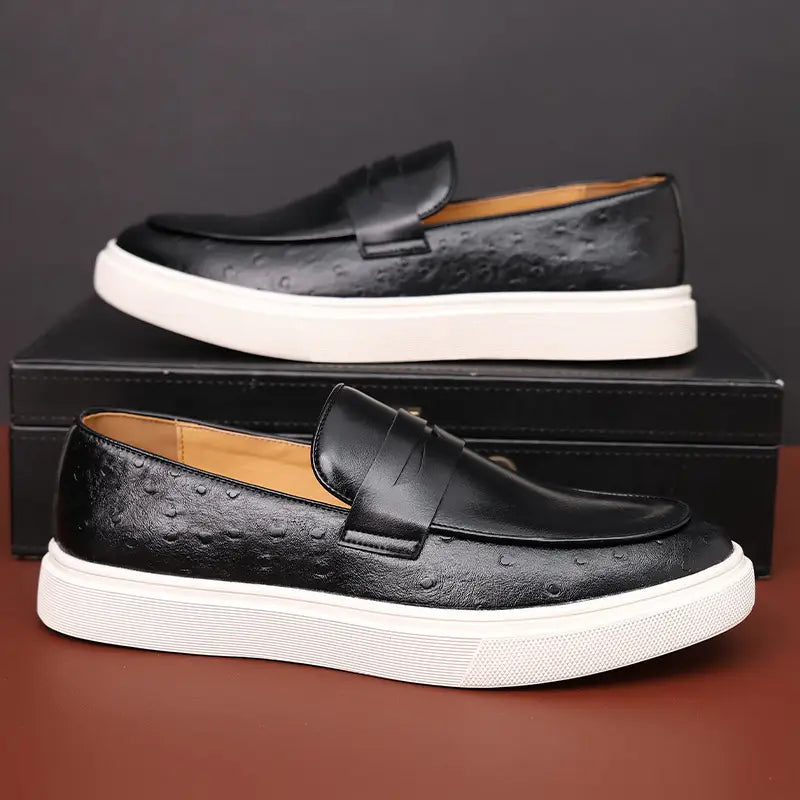 Mocasines para hombres estilo británico de cuero con estampado de avestruz en negro con suela de goma blanca.