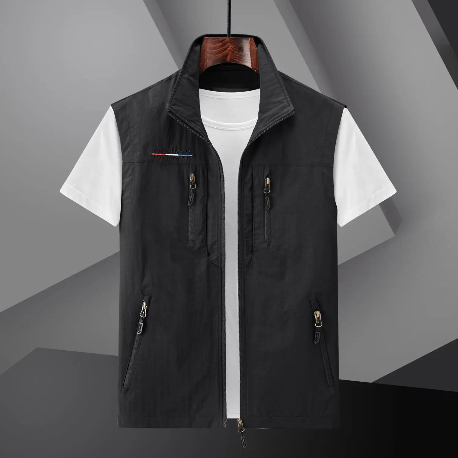 Chaleco utilitario con capucha y cierre tipo cremallera para hombre en color negro, con varios bolsillos y un logotipo sutil en el lado izquierdo del pecho.