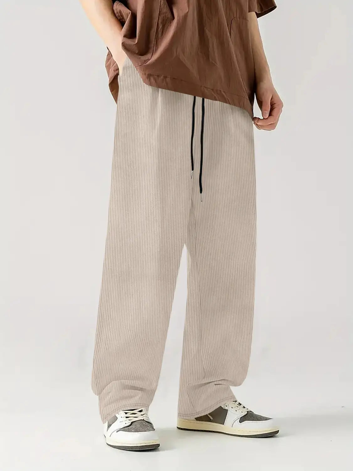 Pantalones casuales rectos de pana color beige con ajuste relajado y cinturilla negra.