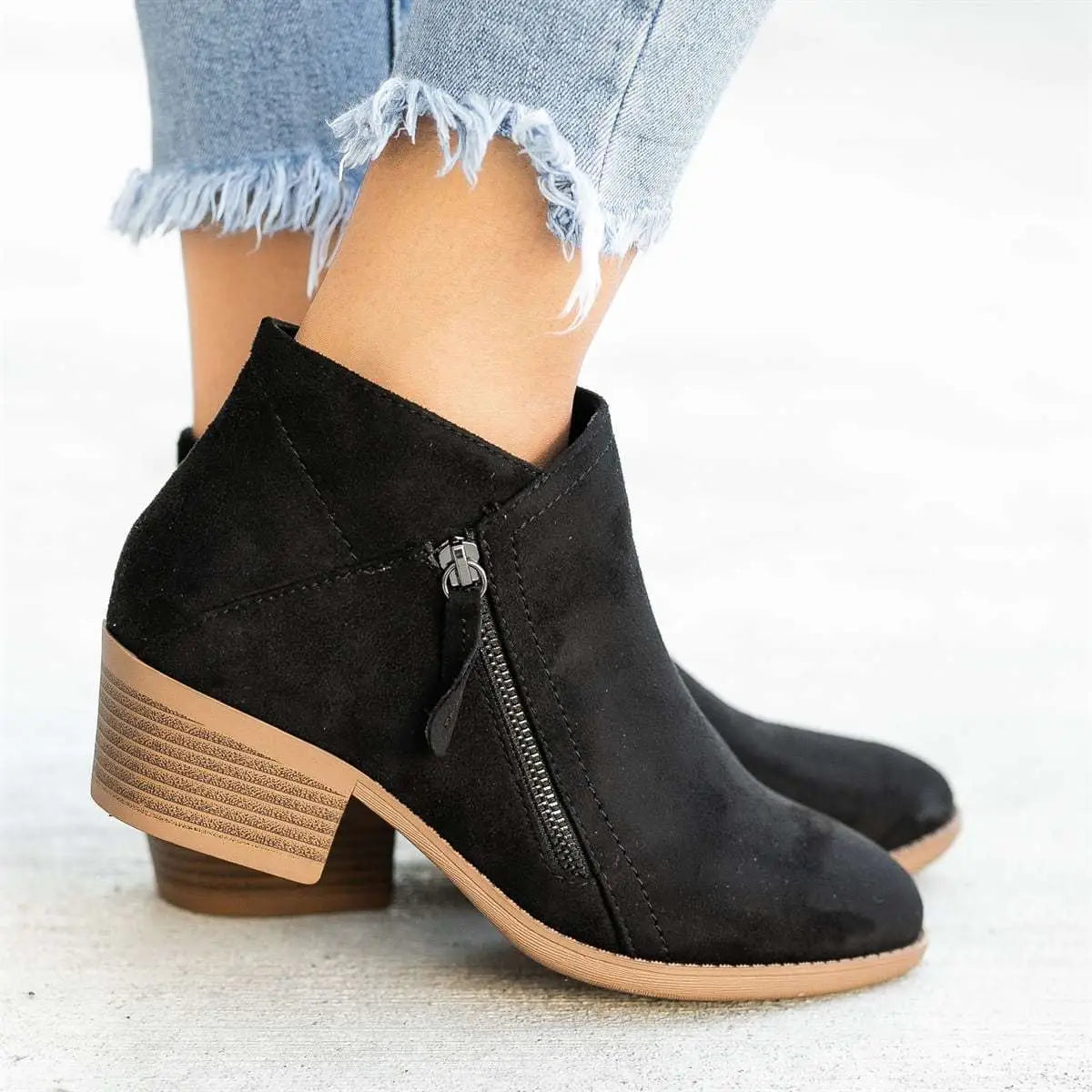 black suede ankle boots by dr. martens featuring a tan stacked chunky heel and side zipper closure