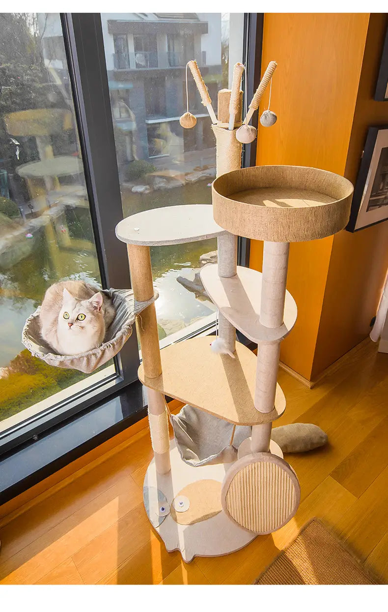 Large wooden cat tree climbing frame with beige and white modern design featuring sisal scratching posts, a circular platform, and hanging toys.