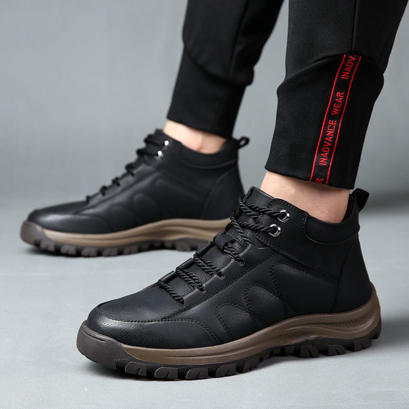 Schwarze Leder-Wanderstiefel für Herren in der hohen Ausführung mit braunen Gummisohlen und Schnürsenkeln, ausgelegt für den robusten Outdoor-Einsatz.