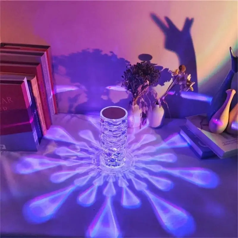 Clear crystal vase table lamp with built-in diamond LED touch control projecting radiant blue and purple floral light patterns for night illumination.