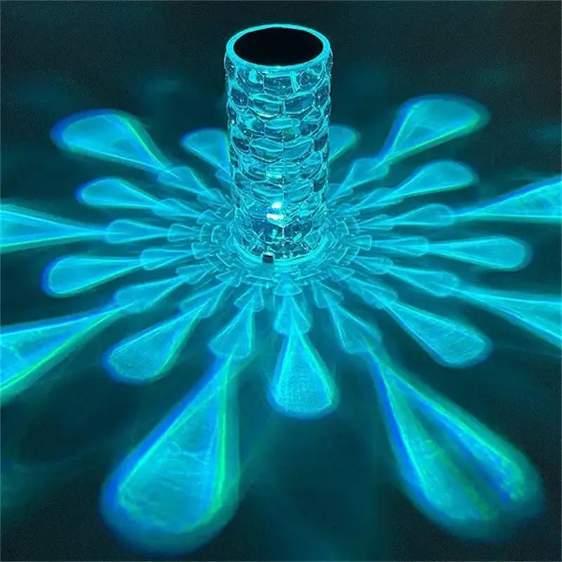 a translucent textured glass crystal table lamp with a central cylindrical body emitting vibrant blue light rays in a floral pattern featuring touch control and diamond led night light functionality