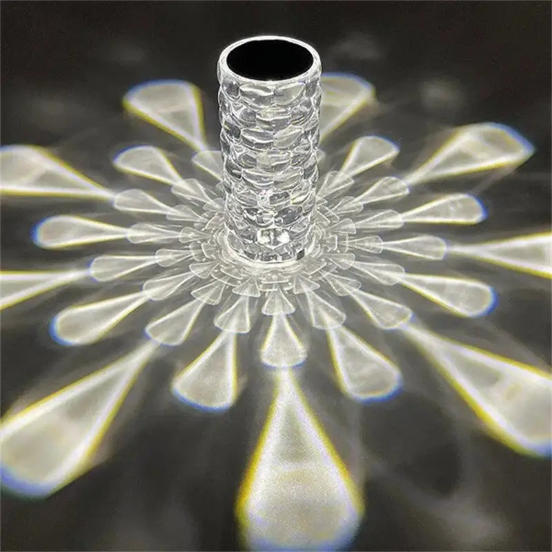 Clear textured glass prism with a central cylindrical stem and radiating petal-like facets refracting colorful beams in a crystal table lamp touch control diamond led night light.