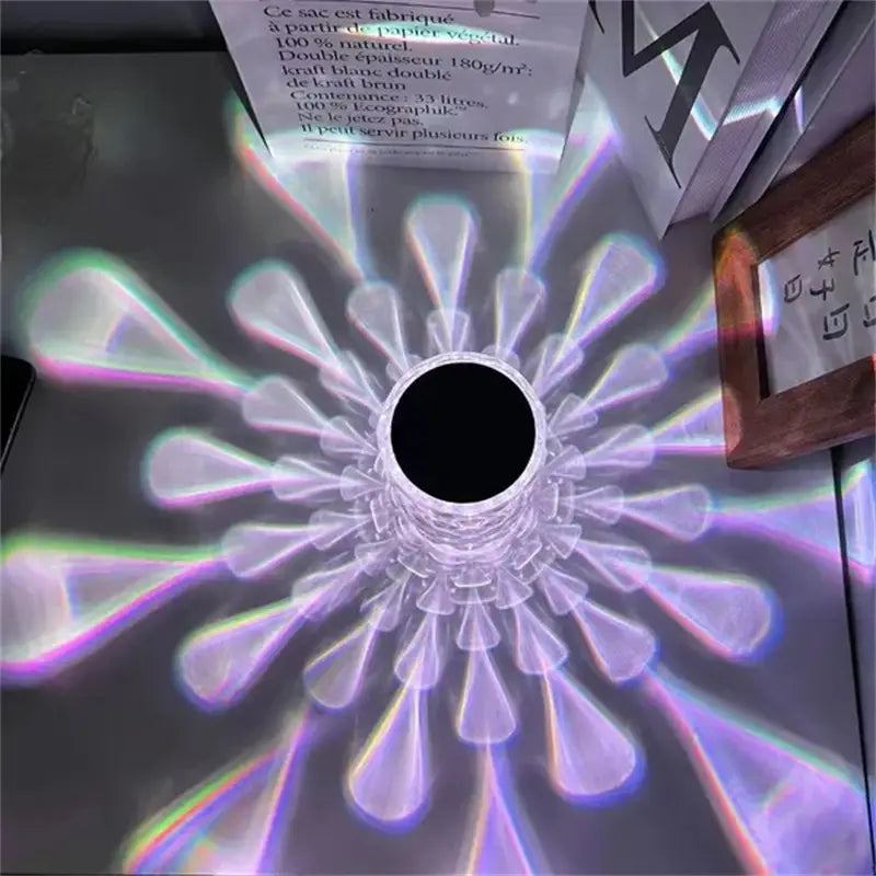 Crystal table lamp touch control diamond LED night light featuring a clear cylindrical paper lantern with a black center and radiating petal-like segments casting colorful rainbow light patterns.