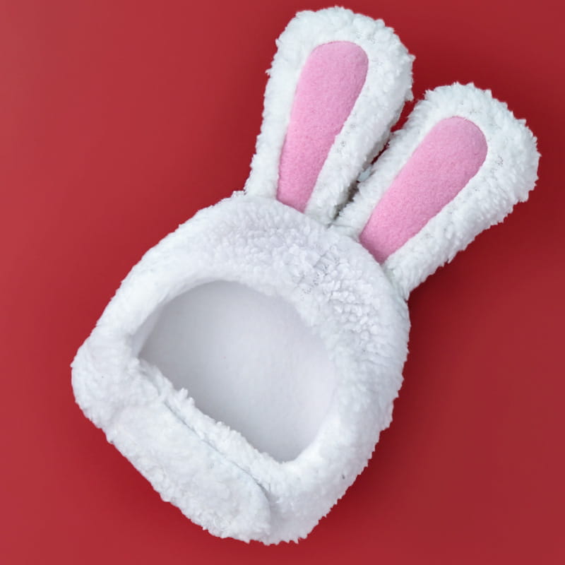 white fluffy bunny-shaped pet bed with pink inner ear linings designed as a plush bunny ear pet hat for small animals