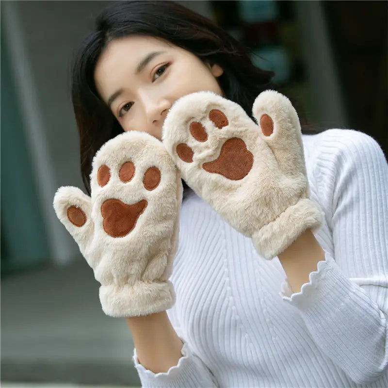 Cream-colored fluffy cat paw plush winter mittens with brown embroidered paw pads made of fuzzy warm material.