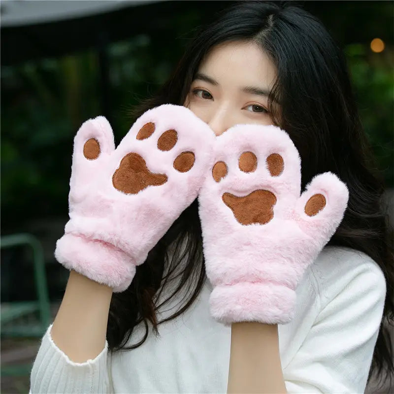 pink fluffy cat paw plush winter mittens made of warm fuzzy material with brown paw print designs.