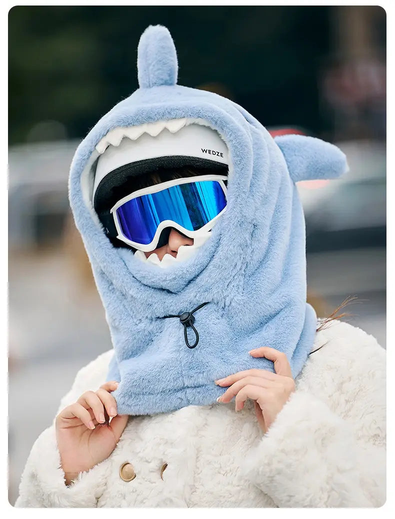 Bonnet d’hiver en peluche de requin bleu clair, avec des dents blanches et une fermeture à cordon de serrage noir, conçu pour la protection des oreilles.