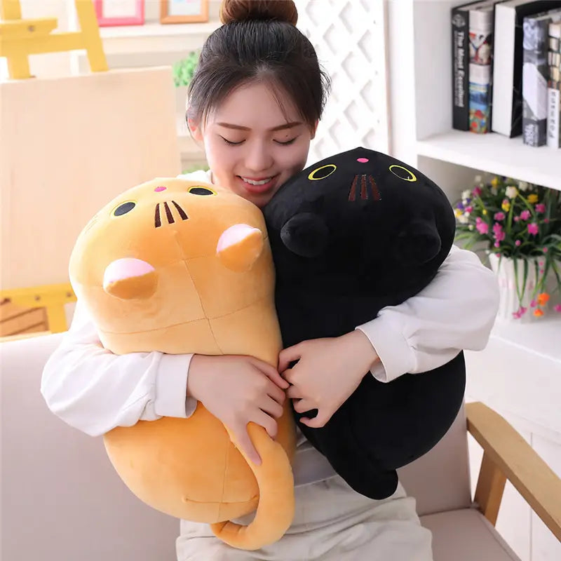 Un coussin pelucheux de chat avec un corps arrondi et souple et des traits du visage brodés, conçu comme un coussin pelucheux de chat gras, jouet en peluche d’animal rembourré.