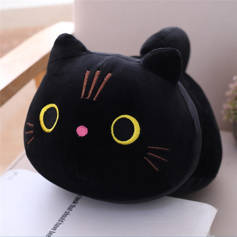 Le coussin pelucheux noir de chat gras présente des yeux jaunes brodés, un nez rose et des moustaches orange, conçu comme un jouet en peluche d’animal rembourré.
