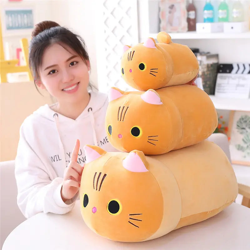 Un lot de trois coussins pelucheux de chat gras orange avec oreilles internes roses et yeux noirs, jouets en peluche d’animal rembourrés