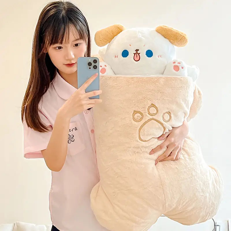 a plush animal pillow radish rabbit and cat toy in cream color with tan ears and blue eyes peeking from a matching fluffy blanket embroidered with paw prints