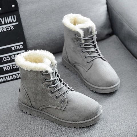 Gray suede martin boots for women featuring fluffy white fur lining and matching laces designed as winter shoes.