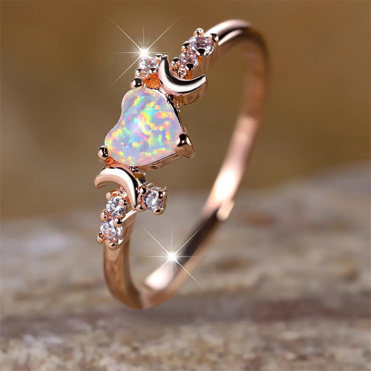 A rose gold heart opal crescent moon ring with diamonds featuring a heart-shaped opal surrounded by crescent moon motifs and clear gemstones.