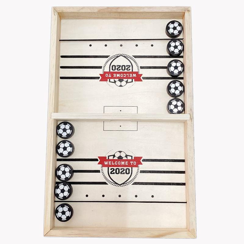 Wooden fast sling puck game featuring black and white ball shaped pieces arranged on a printed soccer field design for tabletop play.